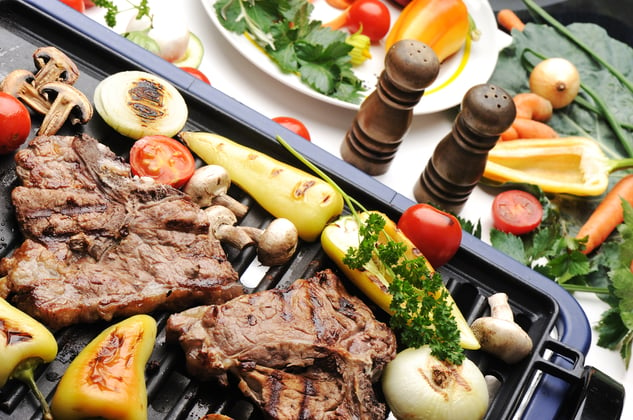 Barbecue, prepared beef meat and different vegetables and mushrooms on grill